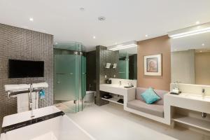 a bathroom with two sinks and a tv and two mirrors at Double - Six, Luxury Hotel - Seminyak in Seminyak