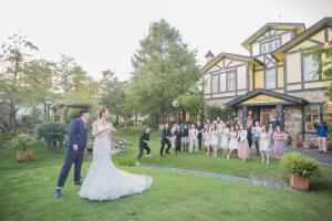 une mariée et un marié marchant devant une maison dans l'établissement Rothenburg Lodge, à Wujie