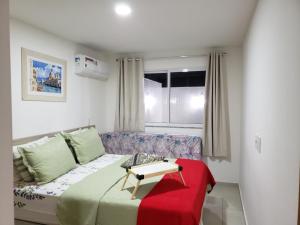 sala de estar con cama y sofá en Le Bon Vivant 108, en Arraial do Cabo