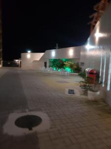 a white building with a patio at night at Le Bon Vivant 108 in Arraial do Cabo