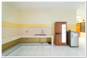 an empty kitchen with a sink and a refrigerator at Koolkost Near Universitas Maranatha 2 Bandung - Minimum Stay 30 Nights in Bandung