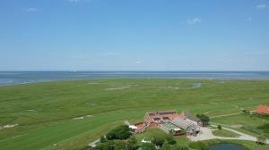 una vista aérea de una casa y del océano en Hotel Hus Achtern Diek en Insel Neuwerk