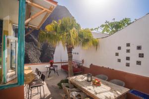 a patio with a table and a palm tree at Casa Estie in Calera