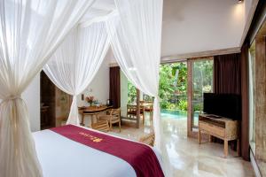 a bedroom with a large bed and a large window at The Kalyana Ubud Resort in Ubud