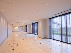 an empty corridor in a building with large windows at LIBER HOTEL Osaka in Osaka +37 photos