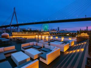 a rooftop deck with couches and a bridge at night at LIBER HOTEL AT UNIVERSAL STUDIOS JAPAN in Osaka
