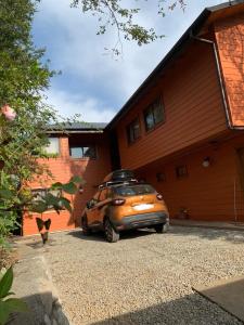 a small car parked in front of a house at cabañas los Ulmos in Licán Ray