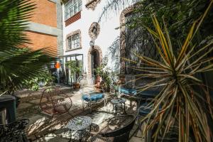 een patio met stoelen, tafels en planten bij Casa Comtesse in Mexico-Stad