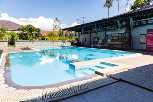 a large swimming pool with blue water at RedDoorz Premium @ Sea Residence Manado in Manado
