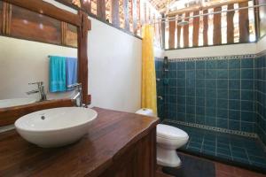 uma casa de banho com um lavatório e um WC em Busuanga Backpackers em Concepcion