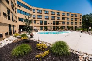 a building with a swimming pool in front of a building at Holiday Inn Philadelphia South-Swedesboro, an IHG Hotel in Swedesboro