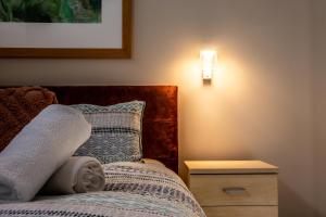 a bedroom with a bed and a lamp at Adina Vineyard in Lovedale