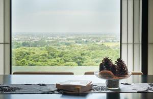 a table with a book and a plant in a bowl at Hotel Royal Chiao Hsi in Jiaoxi