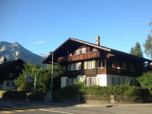 a wooden house with a mountain in the background at Traditional Swiss-Flat in Interlaken