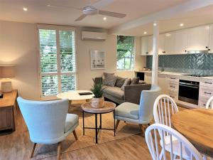 a living room filled with furniture and a kitchen at The Hastings Beach Houses in Noosa Heads