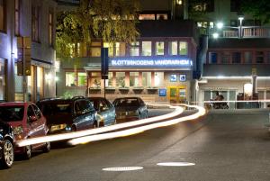 a group of cars parked on a city street at night at Slottsskogen Hotel in Gothenburg