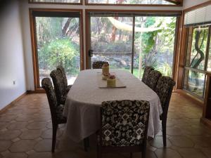 comedor con mesa, sillas y ventanas en Farm guests house, en Somersby