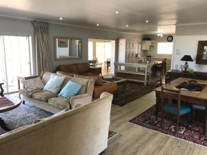 a living room with couches and a dining room at 39 Kabeljauws Road Beach House in Jeffreys Bay