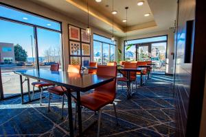 a dining room with tables and chairs and windows at Holiday Inn Express & Suites - Colorado Springs AFA Northgate, an IHG Hotel in Colorado Springs