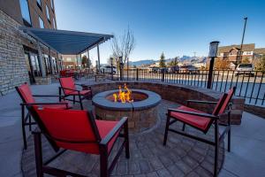 a fire pit with four chairs and a fire place at Holiday Inn Express & Suites - Colorado Springs AFA Northgate, an IHG Hotel in Colorado Springs