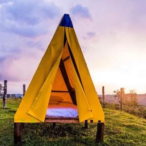 a yellow and blue tent sitting in a field at VALLE DE LAS CECROPIAS in Salento