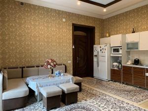 a kitchen with a table and a white refrigerator at Sitorabonu-Guest House in Tashkent