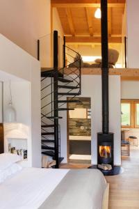 a spiral staircase in a bedroom with a fireplace at Chalet La Vigogne - Spa & Hammam - 14 pers in Le Grand-Bornand
