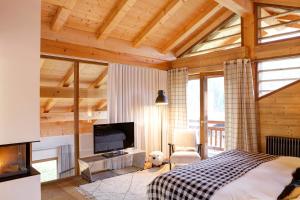 a bedroom with a bed and a flat screen tv at Chalet La Vigogne - Spa & Hammam - 14 pers in Le Grand-Bornand