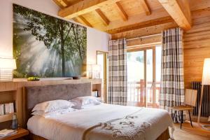 a bedroom with a bed with a large painting on the wall at Chalet La Vigogne - Spa & Hammam - 14 pers in Le Grand-Bornand +23 photos