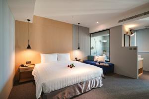 a hotel room with a large bed and a couch at E Hotel in Xinshi