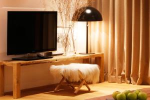 a living room with a television on a table with a stool at Chalet La Vigogne et Spa in Le Grand-Bornand