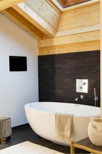 y baño con bañera y techo de madera. en Chalet La Vigogne et Spa en Le Grand-Bornand