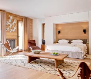 a bedroom with a bed and a table and chairs at Chalet La Vigogne et Spa in Le Grand-Bornand