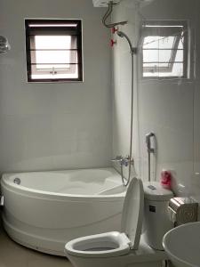 een badkamer met een bad, een toilet en een wastafel bij My Vy Khanh Hotel in Da Nang