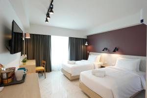 a hotel room with two beds and a tv at Port Canary Airport Hotel in Lat Krabang