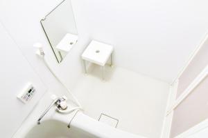 a white bathroom with a mirror and a sink at Guest House One More Heart Kyoto Station South 1 in Kyoto
