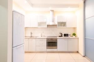 a white kitchen with white cabinets and appliances at Шикарные апартаменты 3 минуты пешком от м Позняки in Kyiv +8 photos