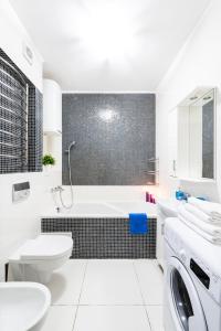 a bathroom with a tub and a toilet and a sink at Шикарные апартаменты 3 минуты пешком от м Позняки in Kyiv