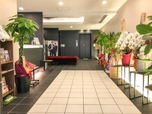 a lobby with potted plants in a store at Hotel Livemax Toyama in Toyama