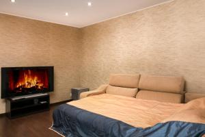 a bedroom with a bed and a tv on the wall at Alex Junior Apartment in Riga