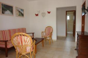 プラヤ・ミジョーンにあるApartamentos Escandell - Formentera Vacacionesのリビングルーム(椅子、テーブル付)