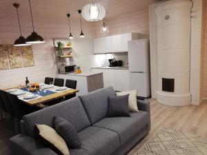 a living room with a couch and a table and a kitchen at Ammatour Apartments in Uro