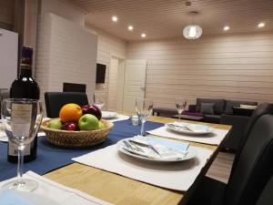 a table with a bowl of fruit and a bottle of wine at Ammatour Apartments in Uro