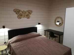 - une chambre avec un lit, une table et un miroir dans l'établissement Ammatour Apartments, à Uro
