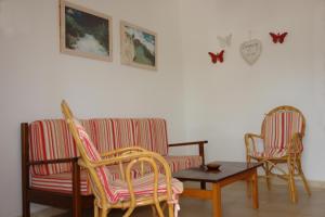 プラヤ・ミジョーンにあるApartamentos Escandell - Formentera Vacacionesのリビングルーム(椅子2脚、ソファ、テーブル付)