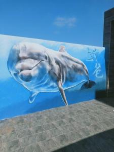 a mural of a dolphin on a wall at Oppa Homestay in Magong