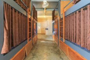einen Flur in einer Schule mit orangefarbenen und blauen Wänden in der Unterkunft Hostel Bukit Sangcure in Nusa Penida