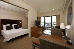 a hotel room with two beds and a television at The Sebel Auckland Viaduct Harbour in Auckland