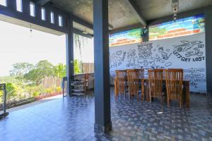 uma sala de jantar com cadeiras de madeira e uma parede com graffiti em Hostel Bukit Sangcure em Nusa Penida