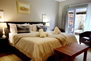 a bedroom with a large bed and a window at Kududu Guest House in Addo +48 photos